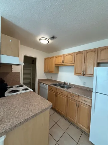 a kitchen with granite countertop a sink stainless steel appliances and cabinets