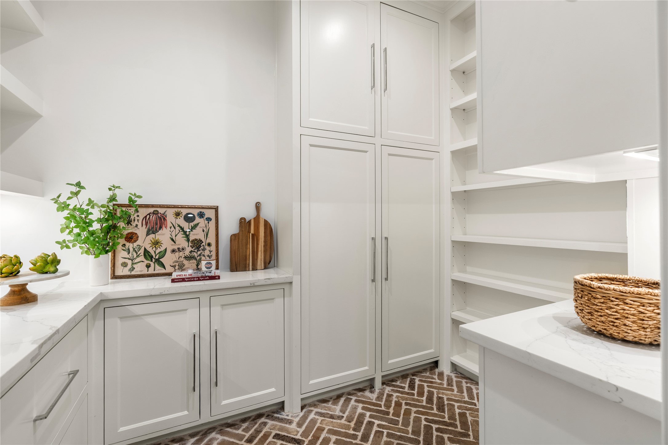 925 Tulane Street, Unit A Houston, TX 77008 - Photo 20 of 49 Floor-to-ceiling shelving and cabinetry equipped with outlets provide convenient storage in this stunning scullery, while custom brick flooring and quartz counters add great style.
