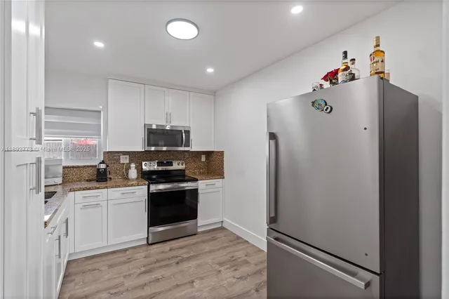 a kitchen with stainless steel appliances a refrigerator sink and cabinets