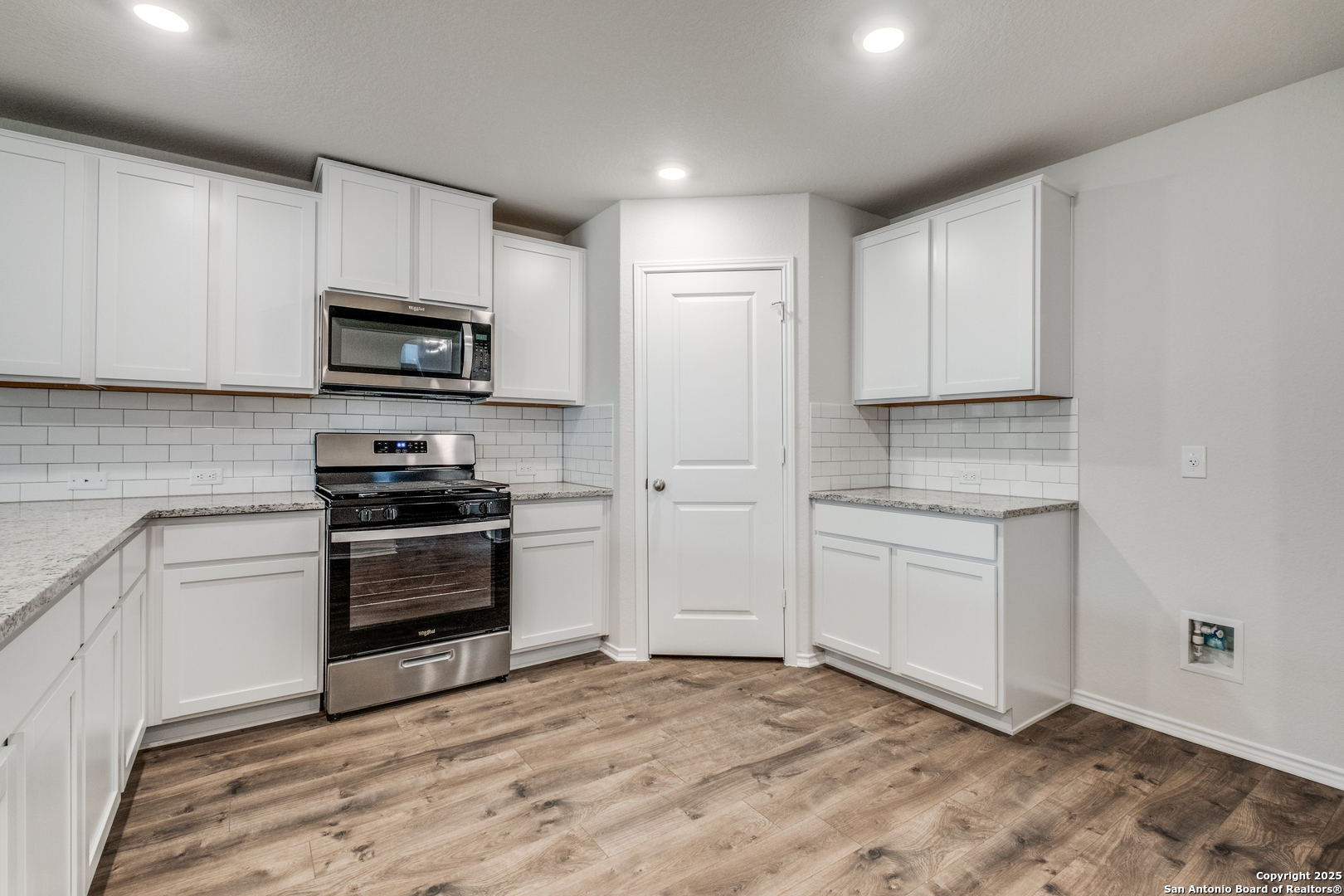 29523 Copper Gate Bulverde, TX 78163 - Photo 9 of 25 a kitchen with granite countertop a stove a sink and a microwave