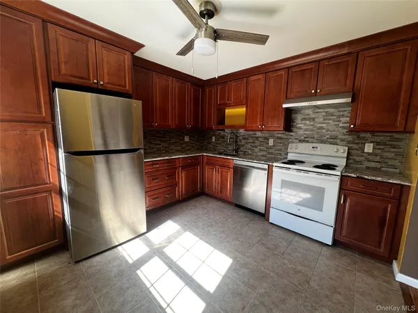 a kitchen with granite countertop a refrigerator stove and microwave