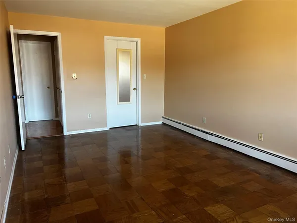 an empty room with wooden floor and closet