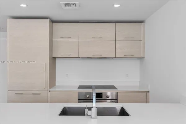 a kitchen with granite countertop white cabinets and stainless steel appliances