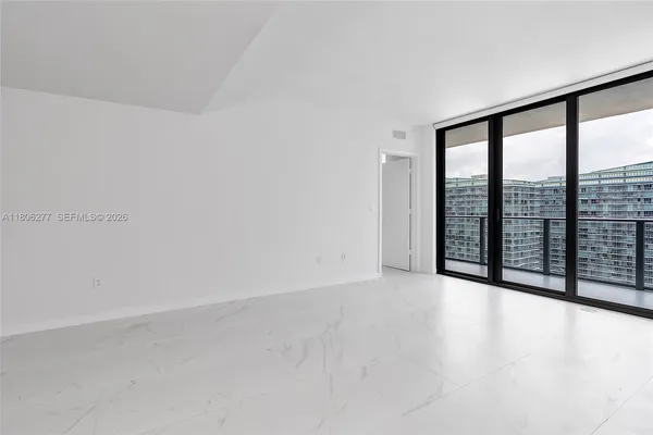 an empty room with sliding glass door and mountain view