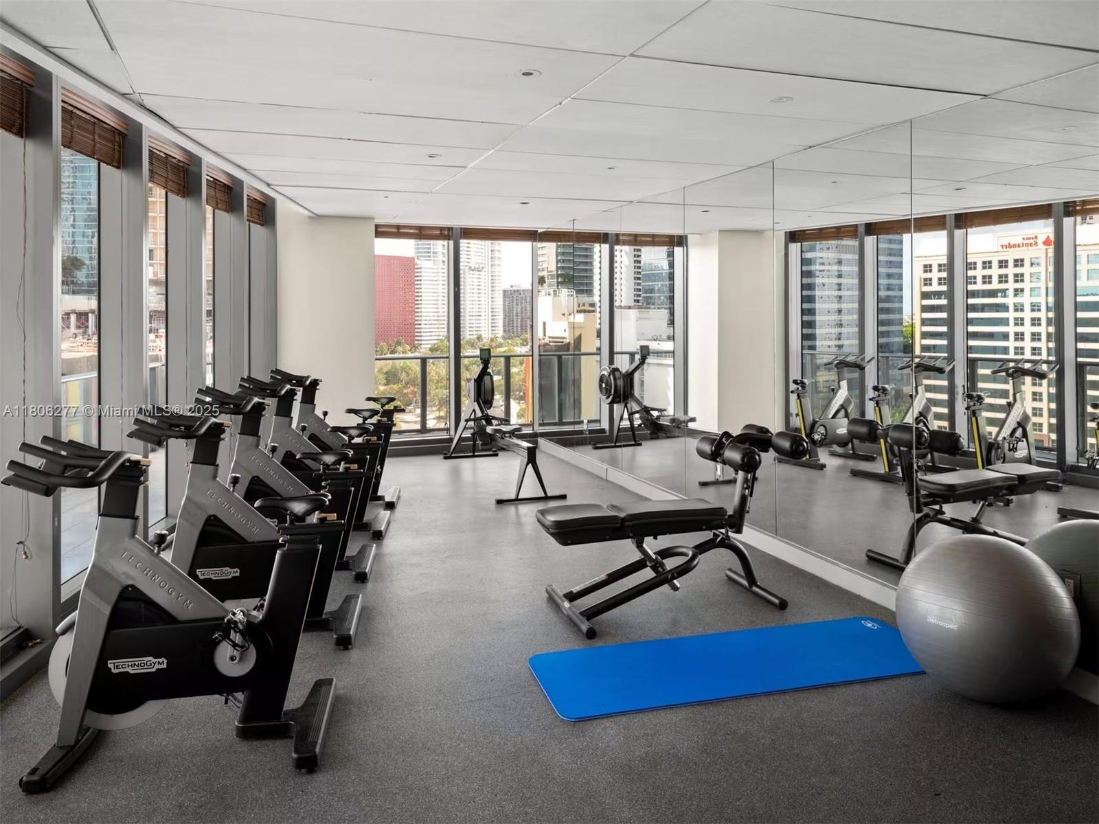 1300 South Miami Avenue, Unit 3211 Miami, FL 33130 - Photo 5 of 38 a room with gym equipment and a large window