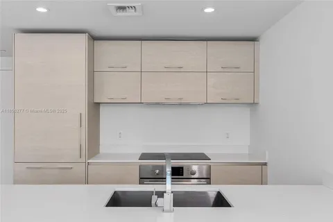 a kitchen with granite countertop white cabinets and stainless steel appliances