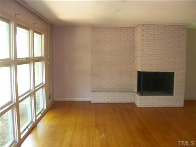 603 Vick Avenue Raleigh, NC 27612 - Photo 3 of 7 a view of an empty room with a fireplace and a window