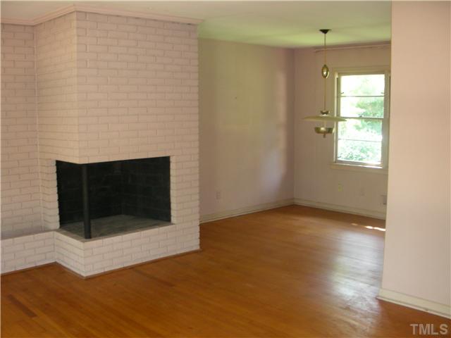 603 Vick Avenue Raleigh, NC 27612 - Photo 4 of 7 a view of empty room with wooden floor and fireplace