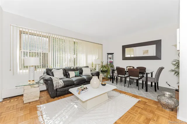 a living room with furniture potted plant and a large window