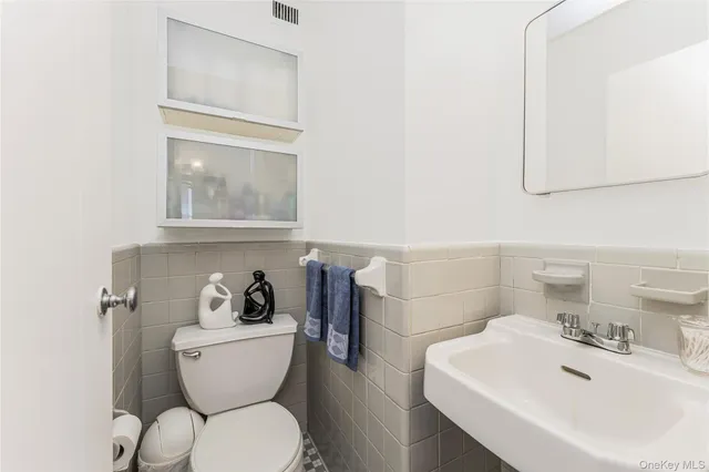 a bathroom with a toilet a sink and mirror