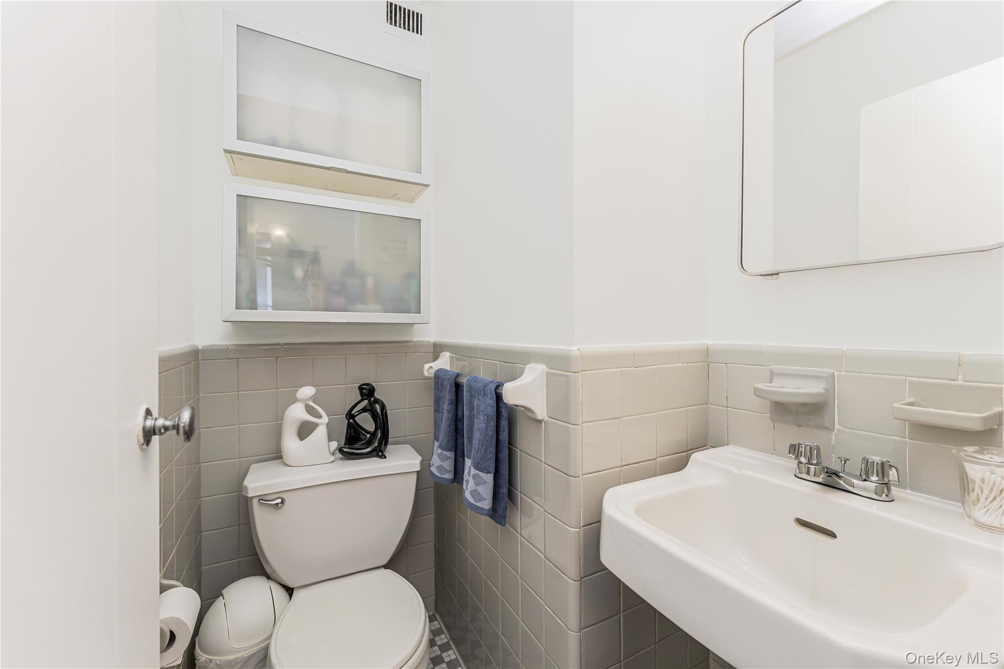 2 Fordham Hill Ovl, Unit 2F Bronx, NY 10468 - Photo 9 of 27 a bathroom with a toilet a sink and mirror