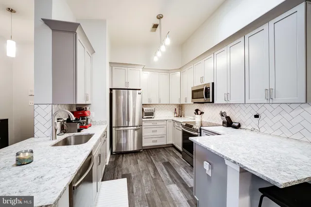 a kitchen with stainless steel appliances granite countertop a refrigerator and a sink