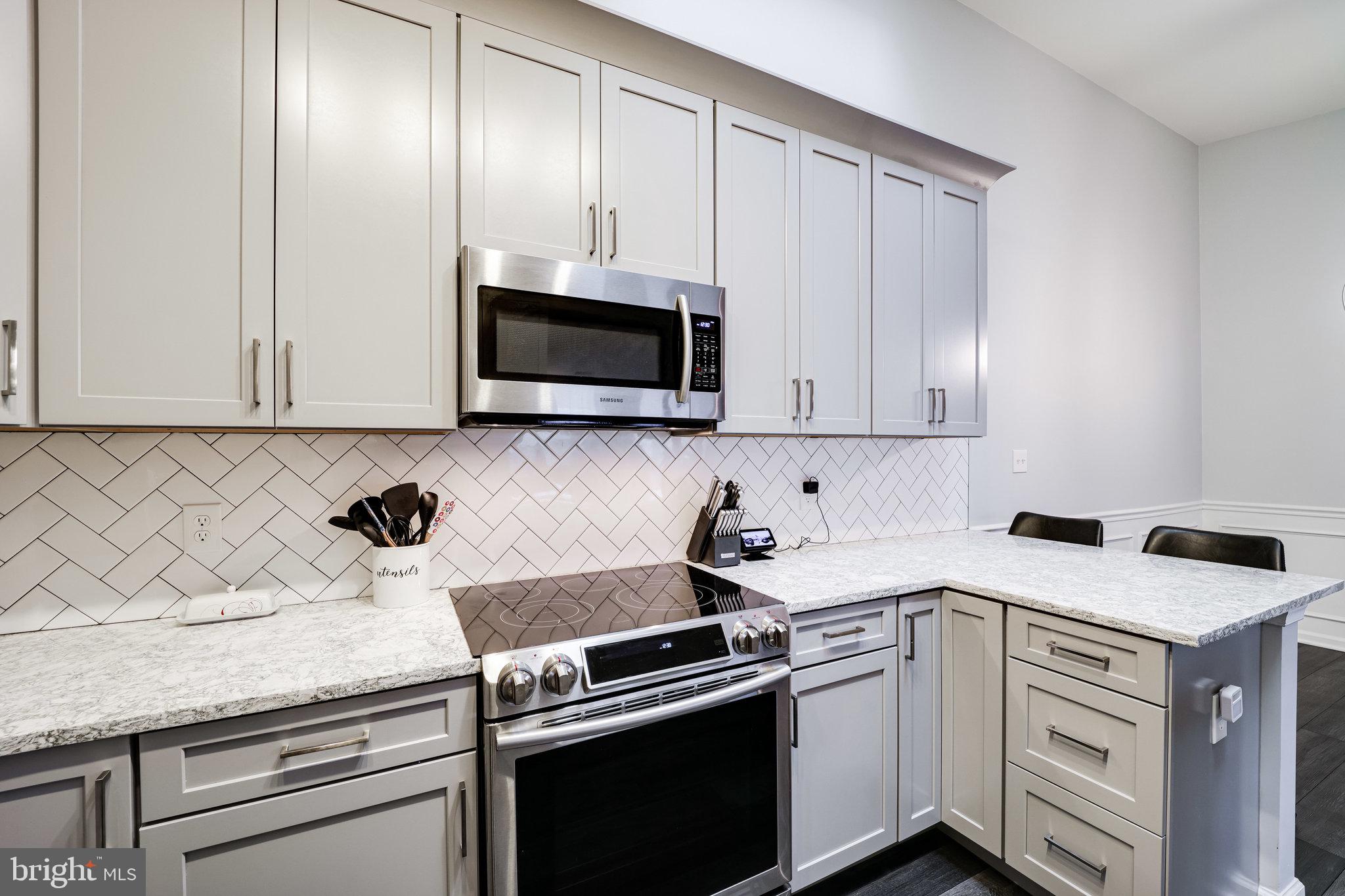 7510 Ashby Lane, Unit J Alexandria, VA 22315 - Photo 19 of 53 a kitchen with granite countertop white cabinets and stainless steel appliances