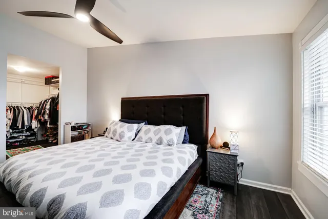 a bedroom with a bed a flat screen tv and a chandelier