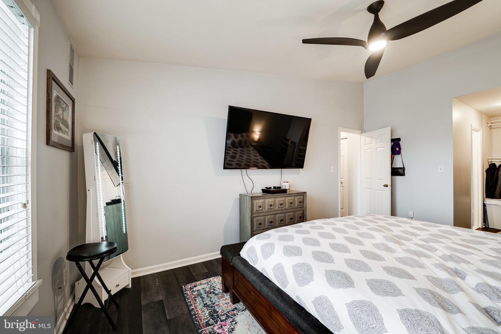 7510 Ashby Lane, Unit J Alexandria, VA 22315 - Photo 23 of 53 a bedroom with a bed a flat screen tv and a chandelier