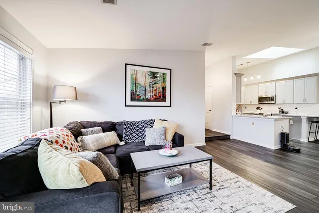 a living room with furniture kitchen view and a table
