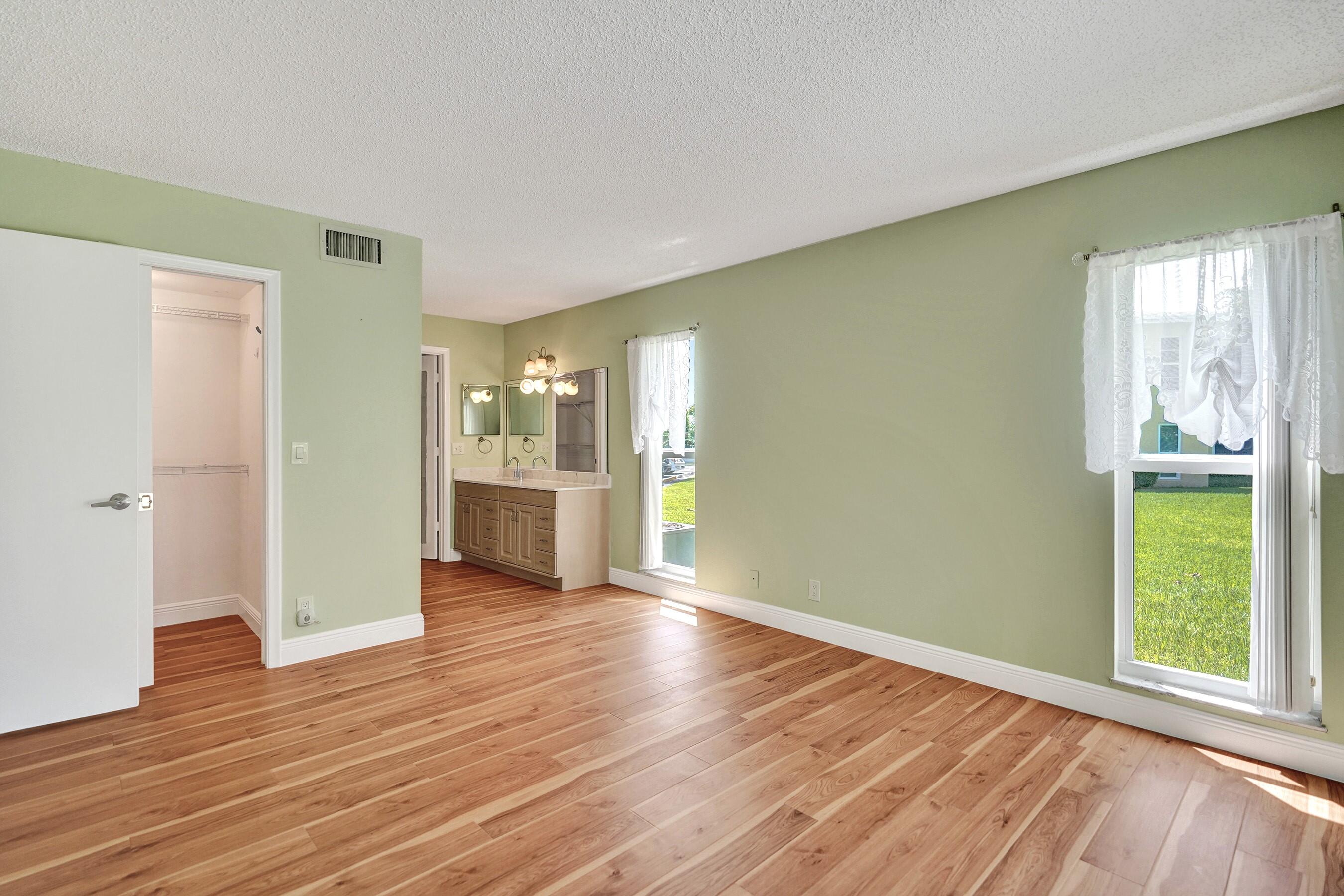 1051 Orange Terrace, Unit 101 Delray Beach, FL 33445 - Photo 11 of 54 a view of an empty room with window and wooden floor