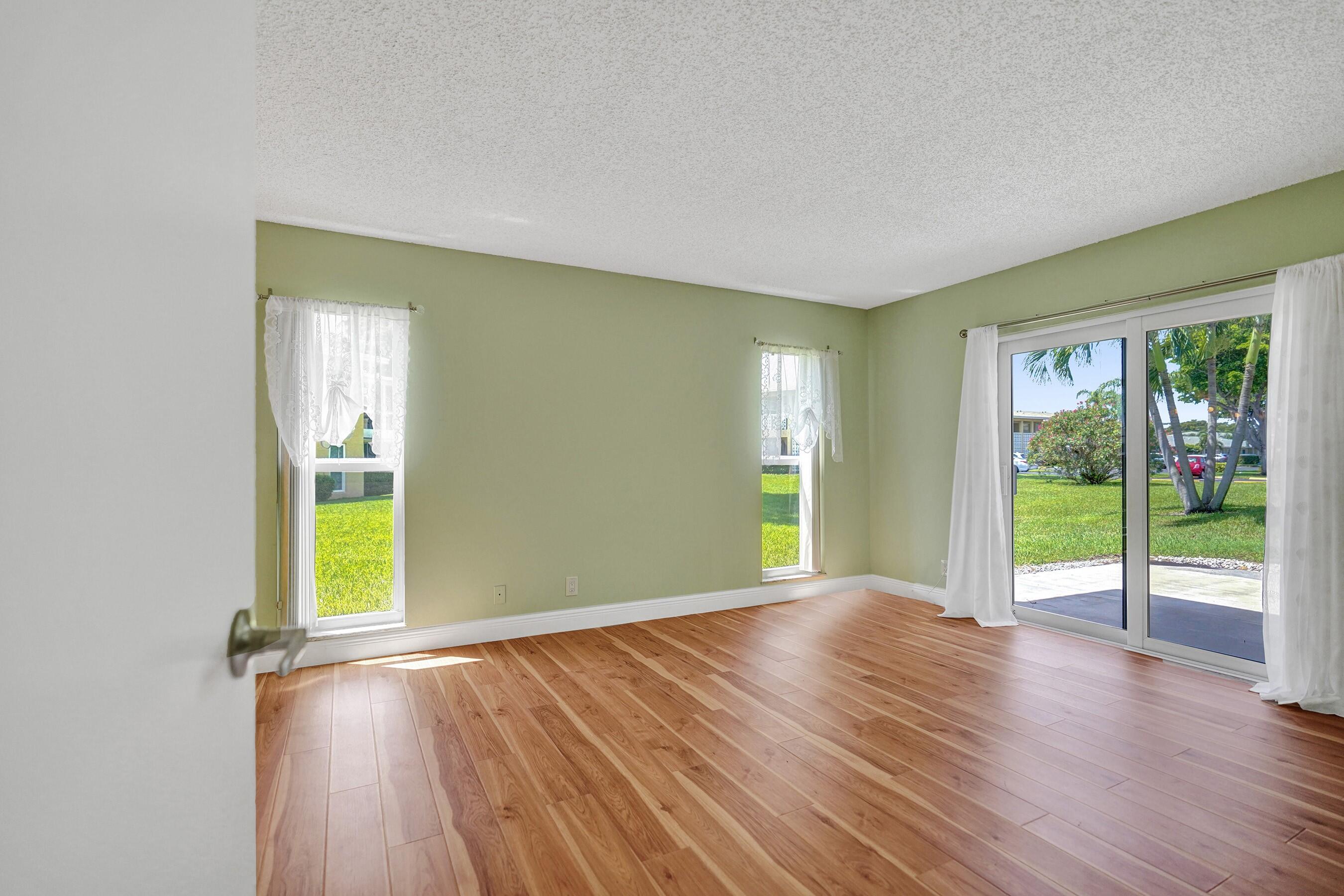 1051 Orange Terrace, Unit 101 Delray Beach, FL 33445 - Photo 12 of 54 an empty room with wooden floor and windows