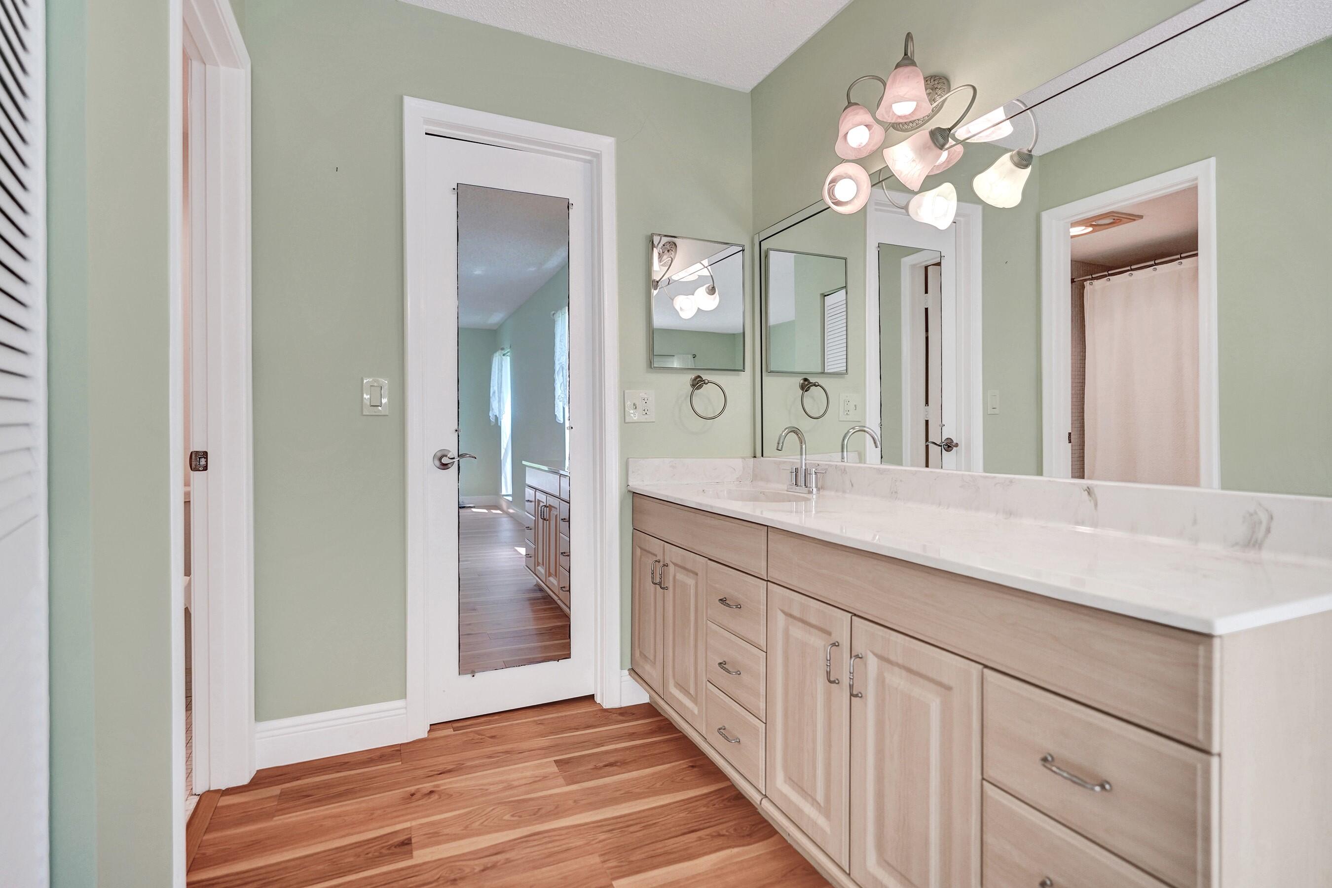 1051 Orange Terrace, Unit 101 Delray Beach, FL 33445 - Photo 14 of 54 a spacious bathroom with a double vanity sink and a mirror