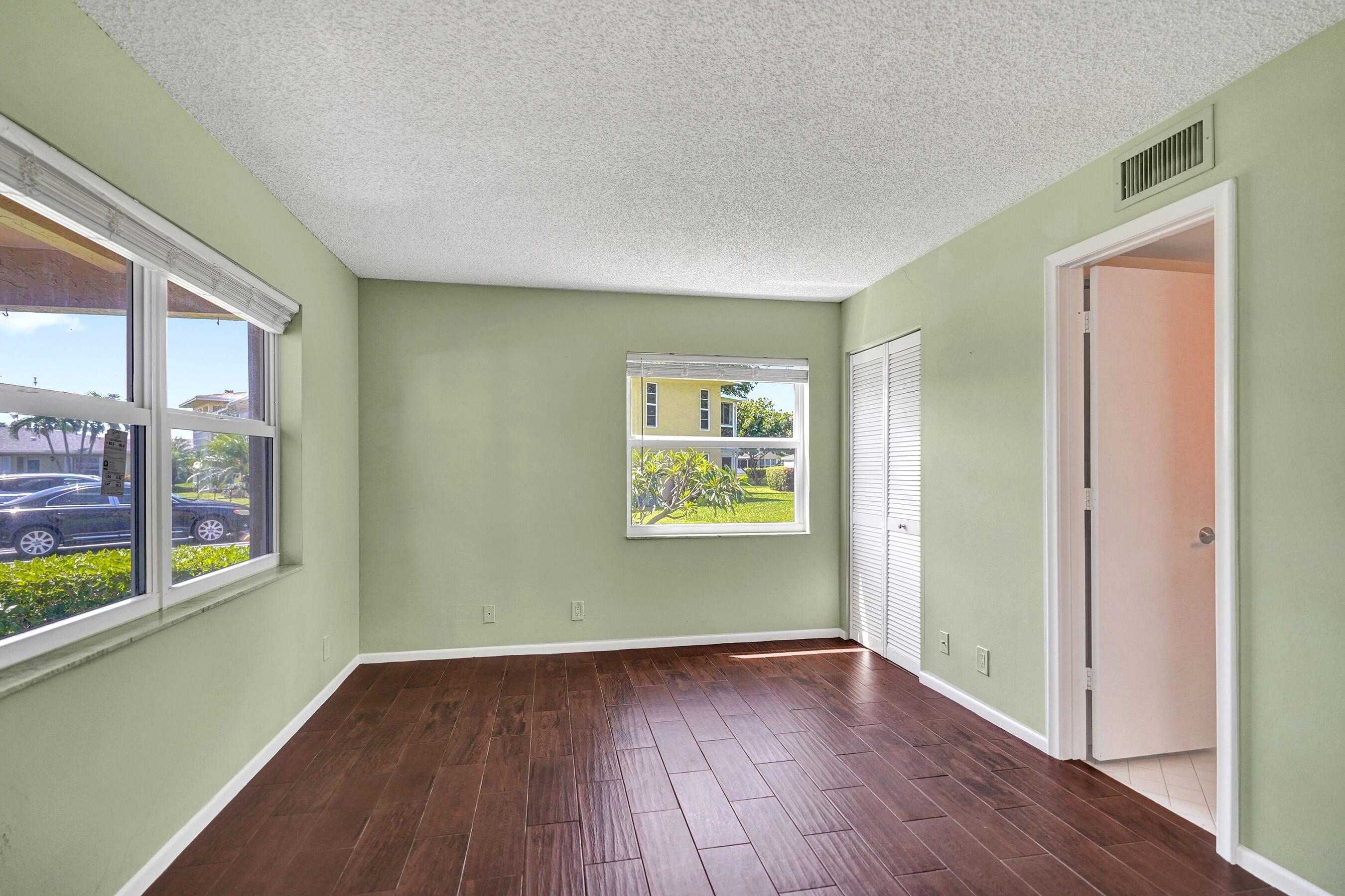 1051 Orange Terrace, Unit 101 Delray Beach, FL 33445 - Photo 16 of 54 an empty room with wooden floor and windows