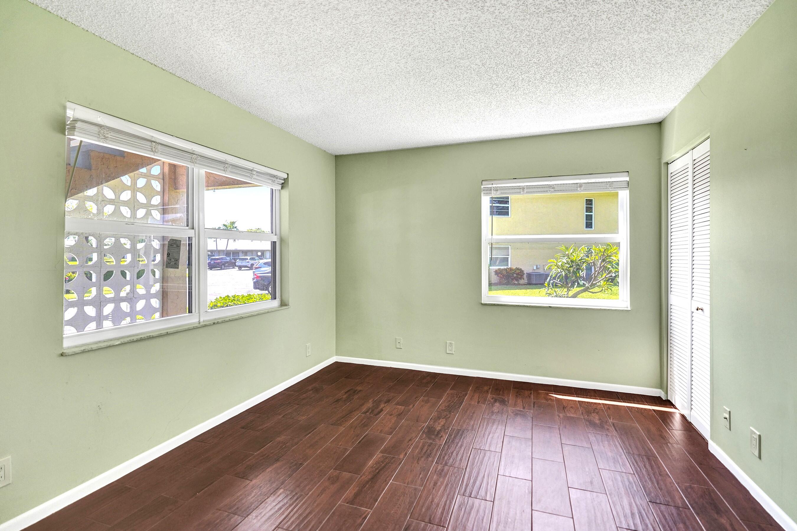 1051 Orange Terrace, Unit 101 Delray Beach, FL 33445 - Photo 17 of 54 an empty room with wooden floor and a window