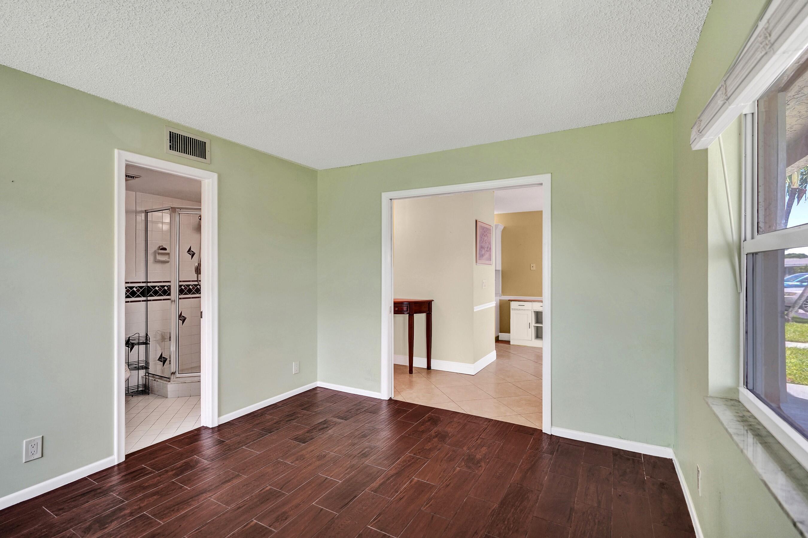 1051 Orange Terrace, Unit 101 Delray Beach, FL 33445 - Photo 18 of 54 a view of an empty room with wooden floor and a window