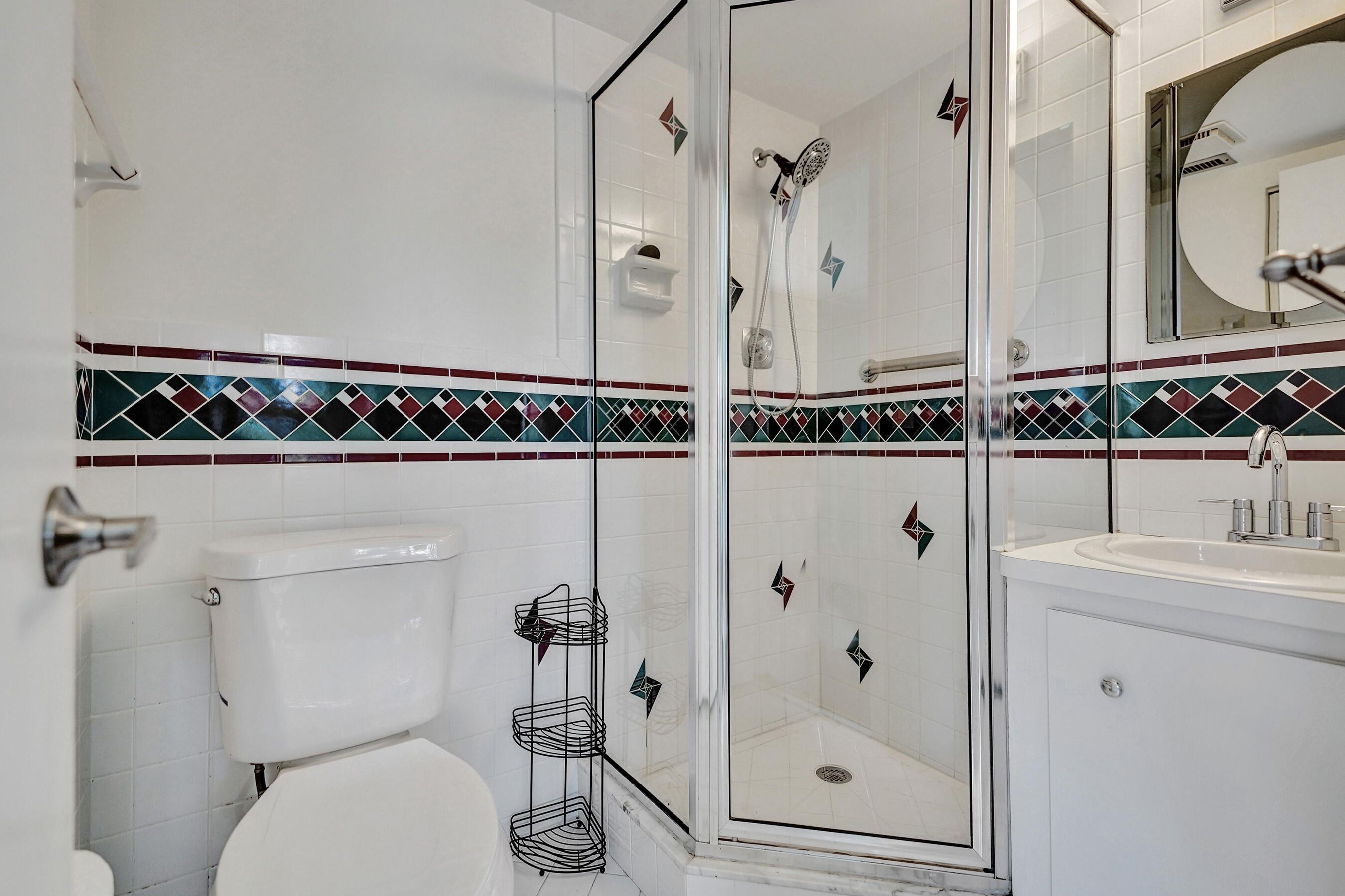 1051 Orange Terrace, Unit 101 Delray Beach, FL 33445 - Photo 19 of 54 a bathroom with a shower toilet and a sink