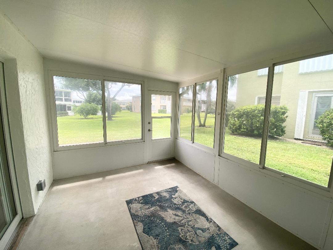 1051 Orange Terrace, Unit 101 Delray Beach, FL 33445 - Photo 23 of 54 an empty room with large windows