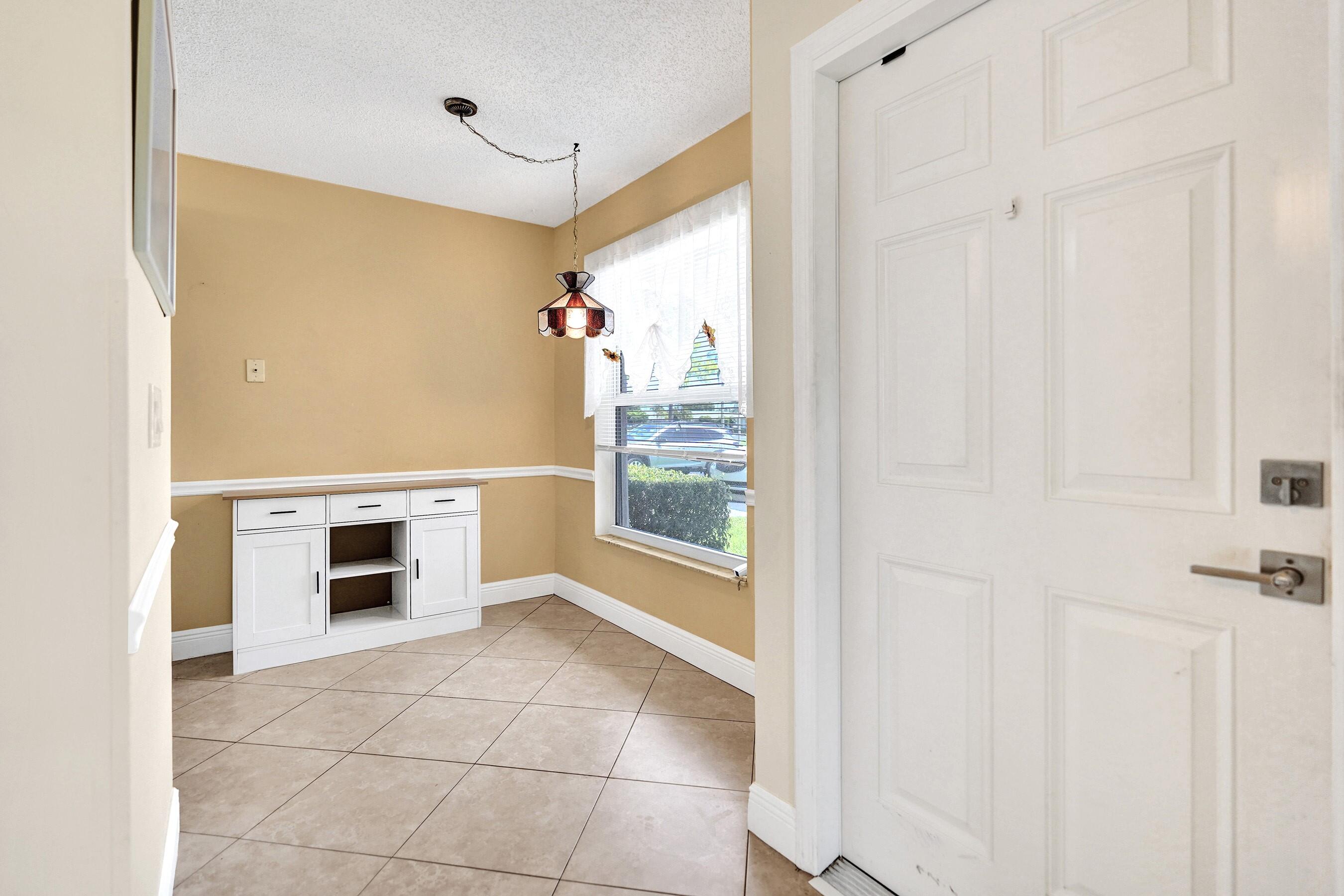 1051 Orange Terrace, Unit 101 Delray Beach, FL 33445 - Photo 32 of 54 a view of a hallway to rooms and kitchen