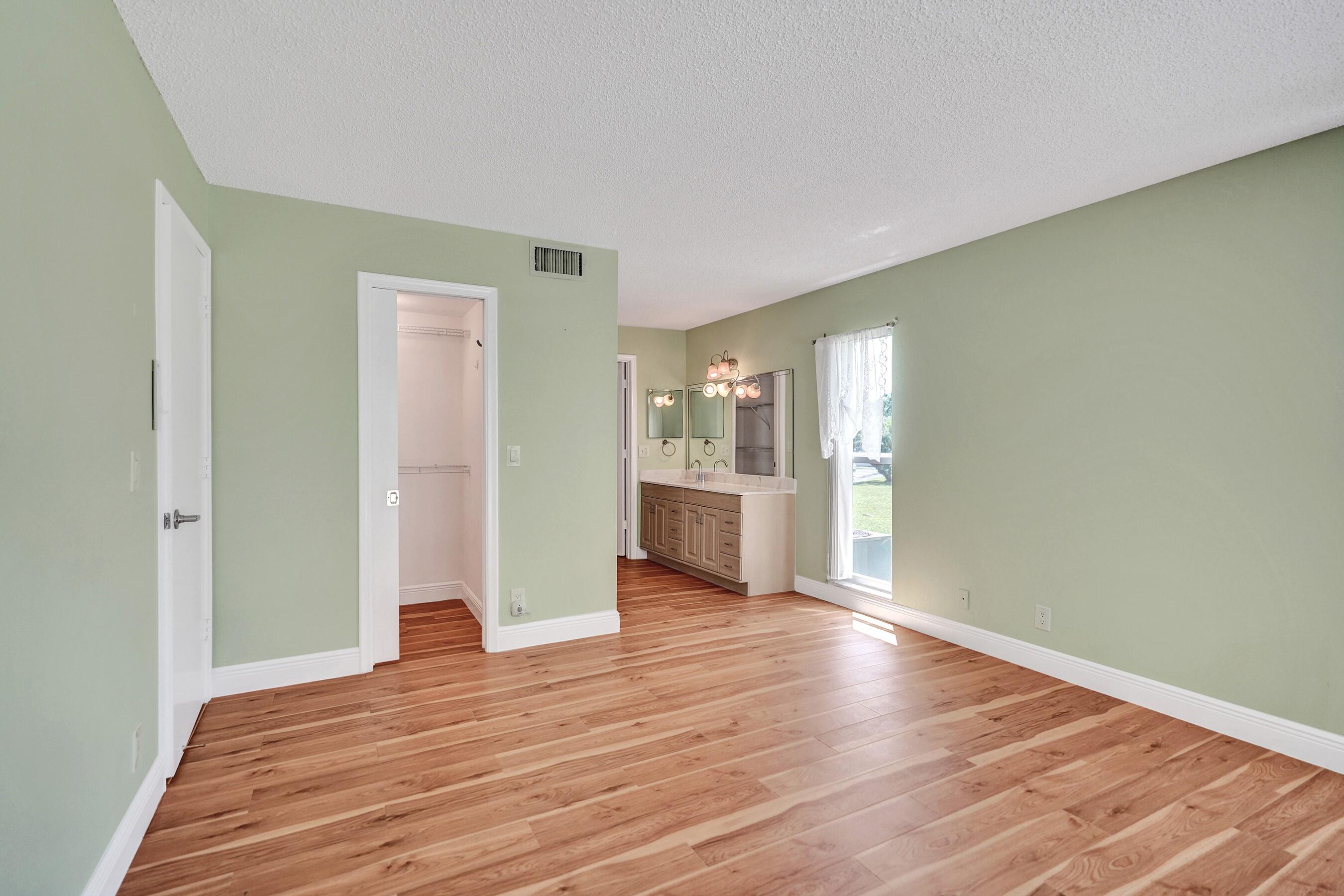 1051 Orange Terrace, Unit 101 Delray Beach, FL 33445 - Photo 33 of 54 a view of a kitchen with wooden floor and a refrigerator