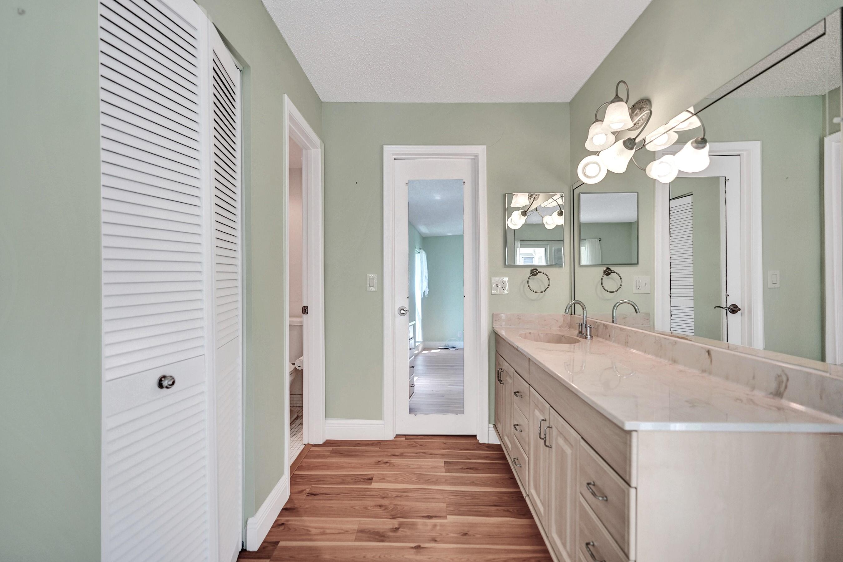1051 Orange Terrace, Unit 101 Delray Beach, FL 33445 - Photo 36 of 54 a spacious bathroom with a granite countertop double vanity sink a mirror and a shower