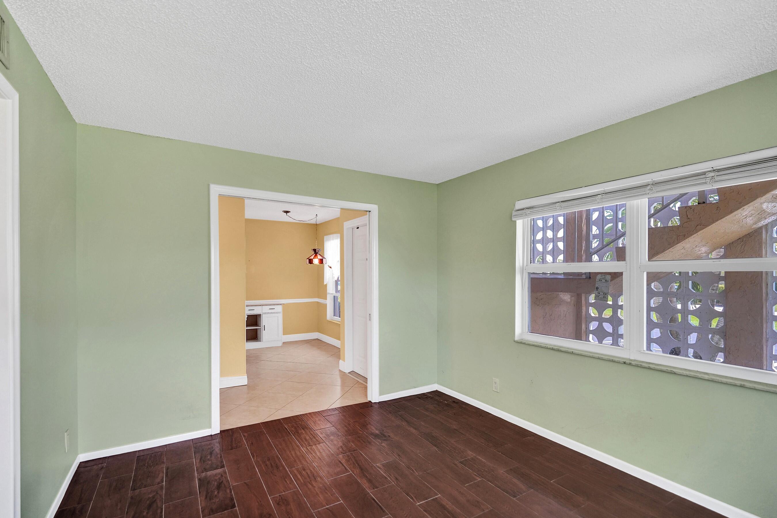 1051 Orange Terrace, Unit 101 Delray Beach, FL 33445 - Photo 37 of 54 a view of an empty room with wooden floor and a window