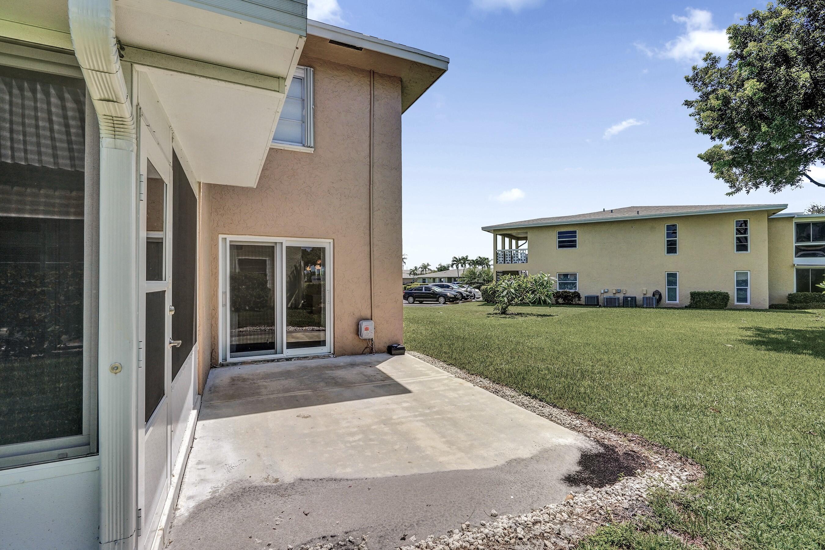 1051 Orange Terrace, Unit 101 Delray Beach, FL 33445 - Photo 40 of 54 a front view of a house with a garden