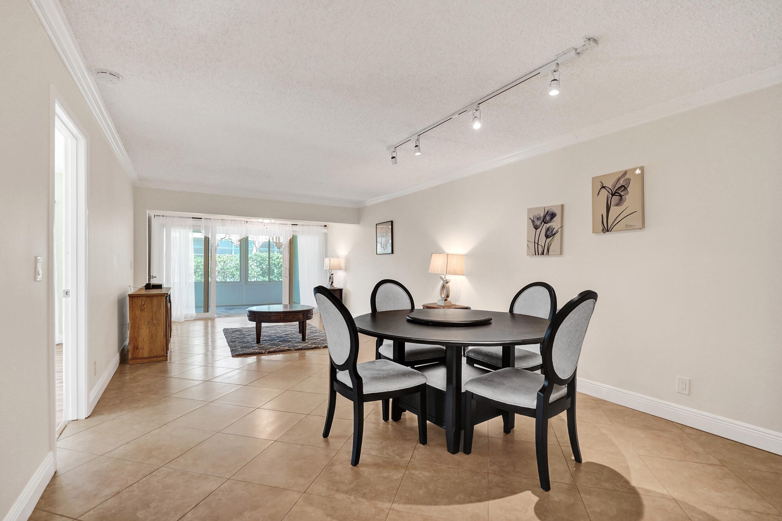 1051 Orange Terrace, Unit 101 Delray Beach, FL 33445 - Photo 4 of 54 a view of a dining room with furniture and a large window