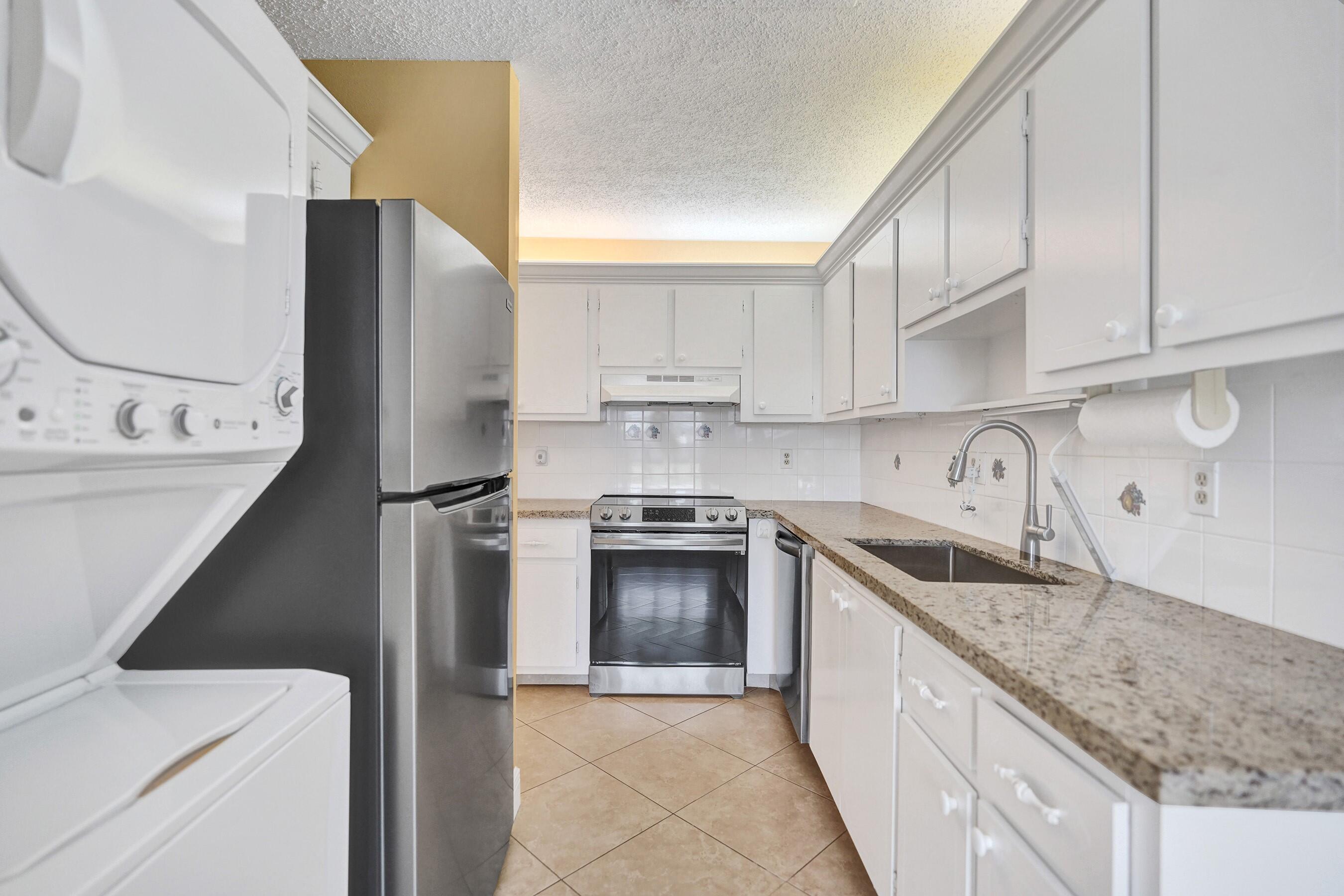 1051 Orange Terrace, Unit 101 Delray Beach, FL 33445 - Photo 41 of 54 a kitchen with a sink cabinets and stainless steel appliances
