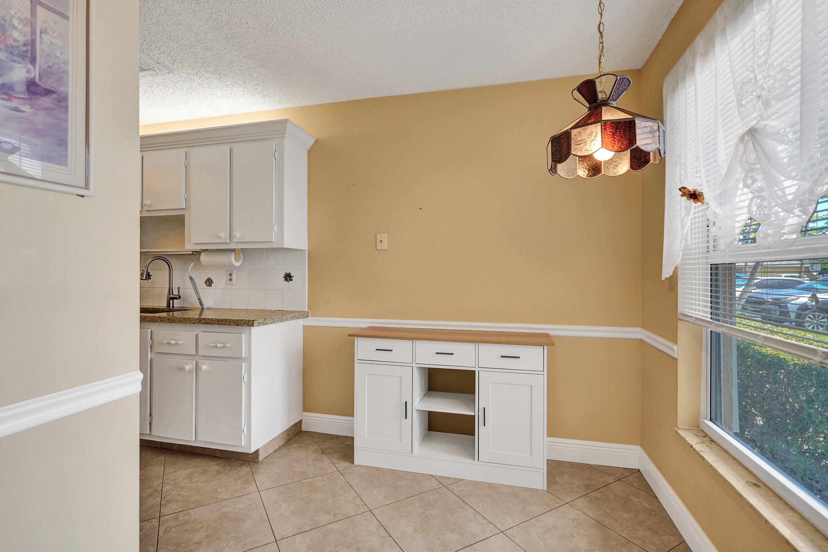 1051 Orange Terrace, Unit 101 Delray Beach, FL 33445 - Photo 43 of 54 a kitchen with white cabinets and white appliances