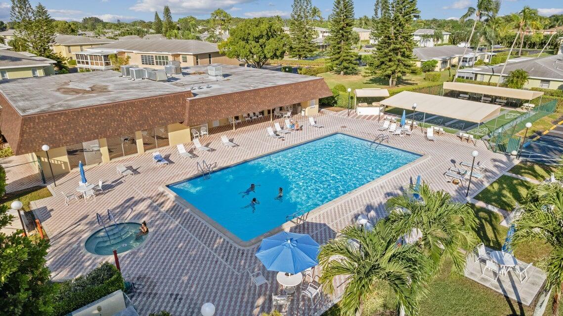 1051 Orange Terrace, Unit 101 Delray Beach, FL 33445 - Photo 45 of 54 a view of a swimming pool with outdoor seating and plants