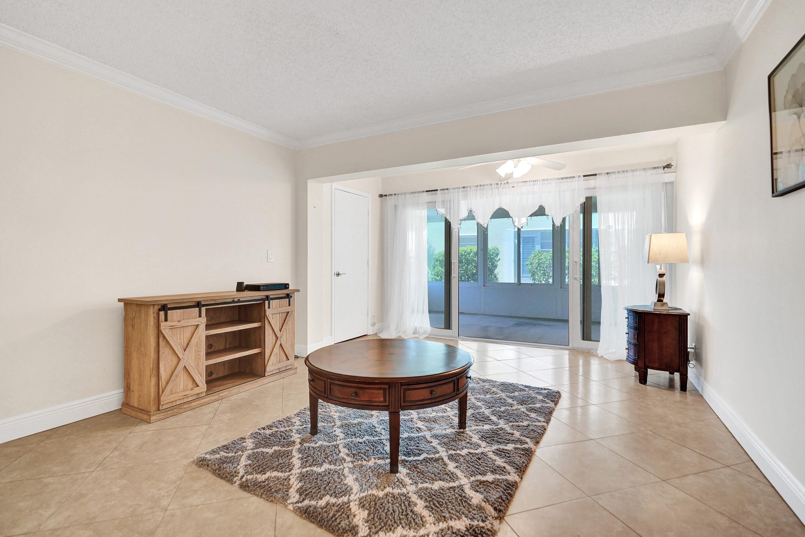 1051 Orange Terrace, Unit 101 Delray Beach, FL 33445 - Photo 5 of 54 a living room with furniture a mirror and a shower