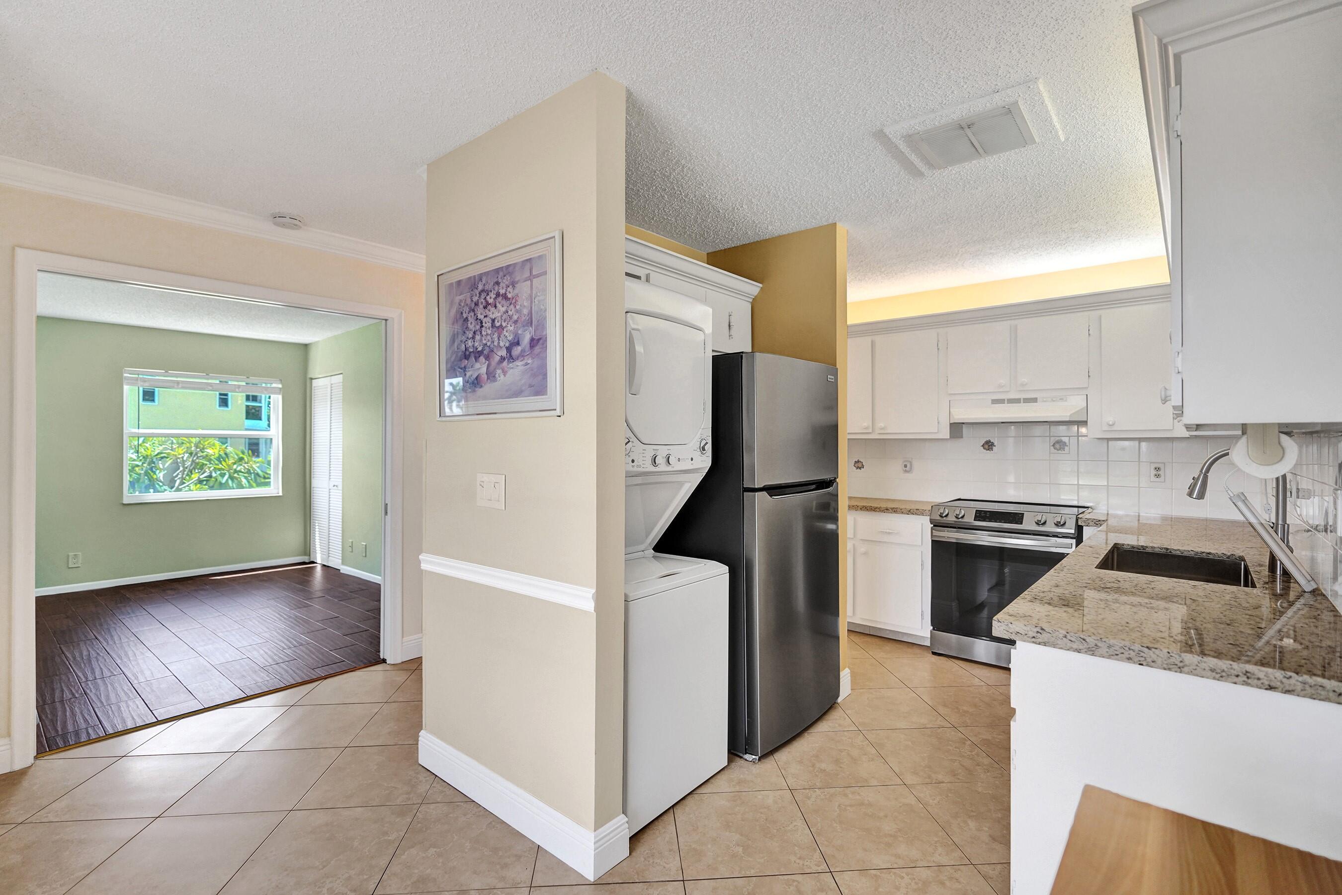 1051 Orange Terrace, Unit 101 Delray Beach, FL 33445 - Photo 8 of 54 a kitchen with granite countertop a refrigerator and a stove top oven