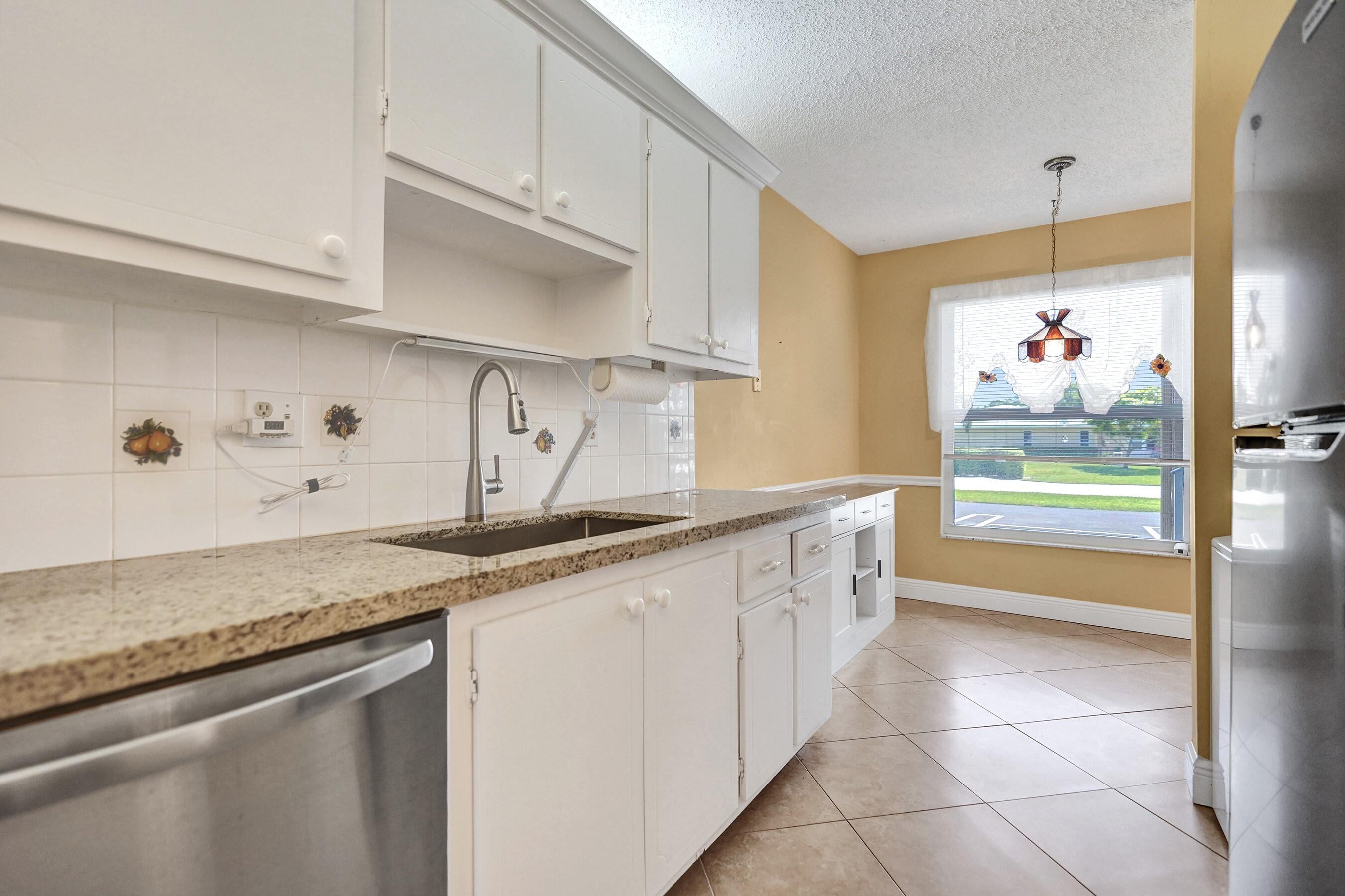 1051 Orange Terrace, Unit 101 Delray Beach, FL 33445 - Photo 9 of 54 a kitchen with stainless steel appliances granite countertop a sink a stove and cabinets