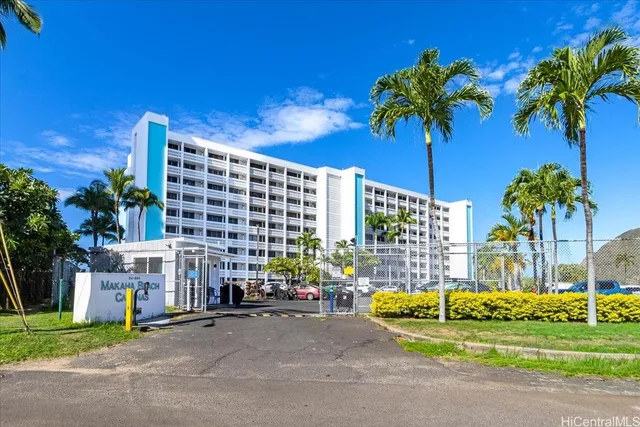 a front view of multi story residential apartment building with yard and outdoor seating