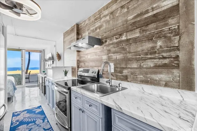 a kitchen that has a sink a stove and a table with wooden floor