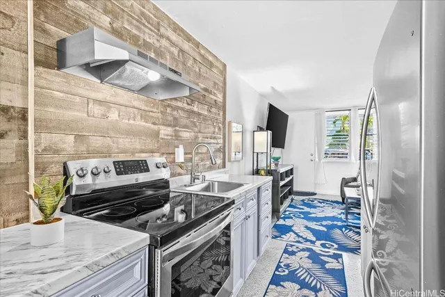 a kitchen with a stove and a wooden floor
