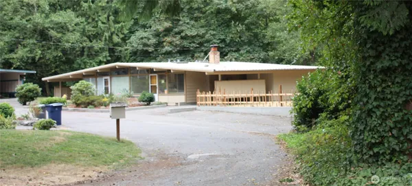 a view of a house with backyard and sitting area