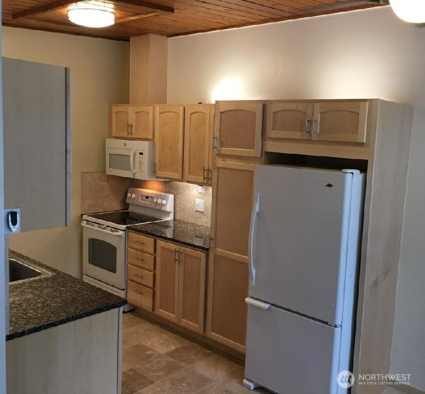 8417 Gold Way Everett, WA 98208 - Photo 6 of 18 a kitchen with granite countertop a refrigerator and a stove