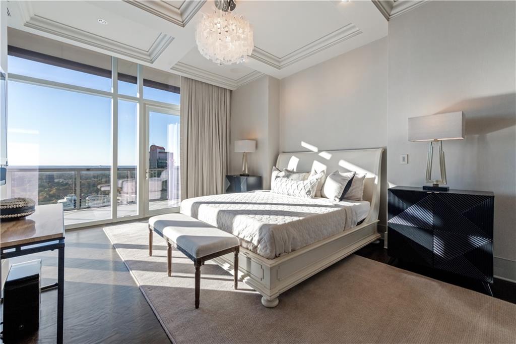 3630 Peachtree Road Northeast, Unit 3401 Atlanta, GA 30326 - Photo 26 of 72 a spacious bedroom with a bed and a chandelier