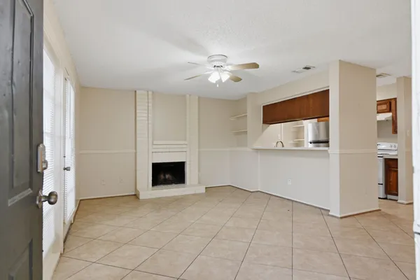 a view of a livingroom with an empty space and a kitchen