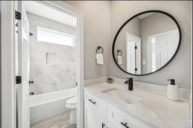 a bathroom with a sink a toilet and a mirror
