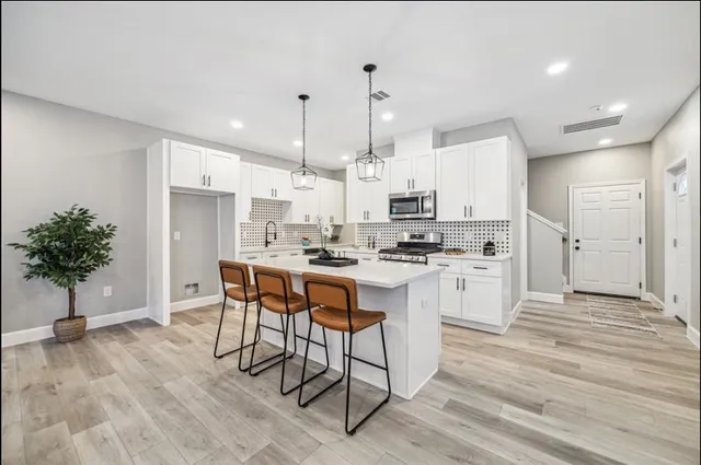 a kitchen with white cabinets and stainless steel appliances