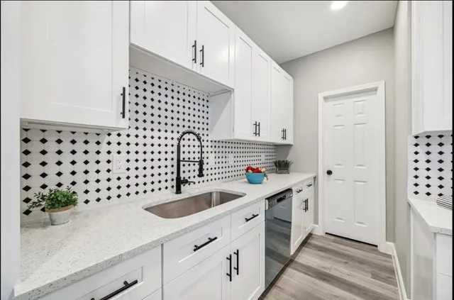 a kitchen with a sink a stove and cabinets